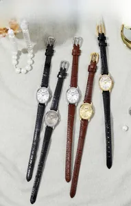 Flat lay of retro oval women's quartz watches with leather straps and pearl accessories