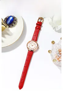 Detail of elegant red leather strap watch with sparkling rose gold diamond dial