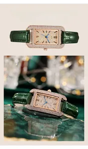 Detailed view of women's gold rectangular watch with crystal dial and green leather strap