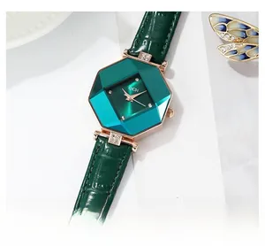 Detail of octagonal green gemstone-cut dial with gold case and leather strap