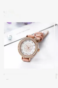 Detail of elegant rose gold watch with crystal bezel and embossed rose floral dial