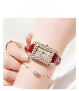 Close-up of square rhinestone bezel watch with champagne dial and red leather strap