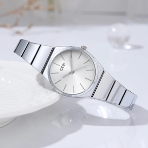 Minimalist silver women's watch with bamboo style link bracelet on white ceramic plate
