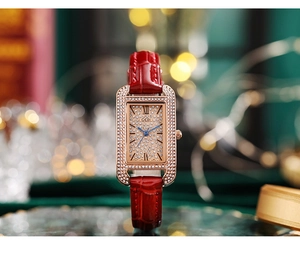 Macro view of square rose gold watch with crystals and red alligator leather strap