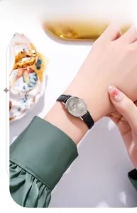 Elegant oval watch with black leather strap and champagne dial worn on a female wrist