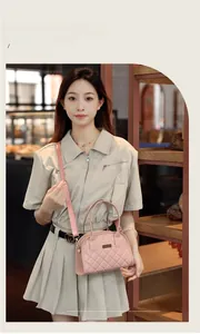 Close-up of pink quilted handbag with gold hardware detail styled on a model in a cafe