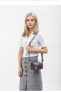Detailed view of fashionable crossbody camera bag with colorful LOVE strap and patchwork