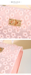 Detail of pink floral lace embroidery and golden buckle on a mini crossbody bag