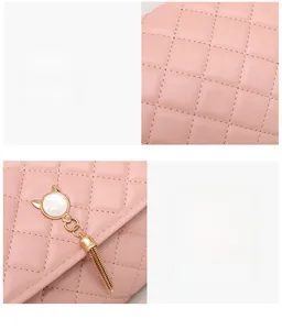 Detail of pink quilted handbag showing gold cat tassel pendant and premium stitching