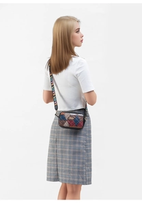 Detail view of quilted patchwork crossbody bag with colorful LOVE wide strap and metal buckle