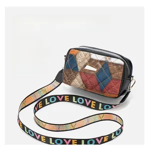 Detail of color block camera bag with geometric quilting and LOVE patterned wide strap