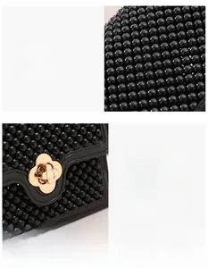 Détail d'un sac à perles noires avec fermoir tournant en métal doré en forme de trèfle