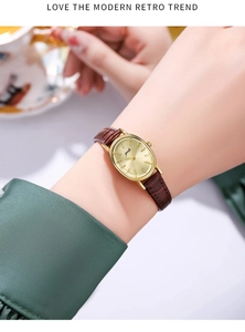 Detail of vintage oval gold quartz watch with brown crocodile embossed leather strap