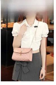 Pink quilted shoulder bag with gold tassel detail and chain strap worn by a model