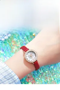 Detailed shot of lady watch with red leather strap and sparkling rhinestone bezel