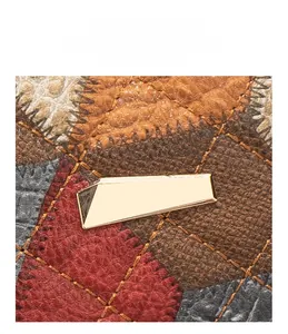 Close-up of multicolor leather patchwork camera bag with quilted stitching and gold buckle