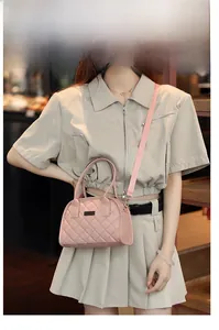 Detailed view of a pink quilted crossbody bag with stylish shoulder strap and hand handle