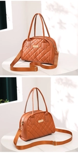 Detail view of caramel quilted handbag with gold hardware and wide nylon strap