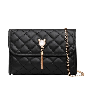 Quilted black crossbody bag with cat head hardware and metallic tassel on a gold chain