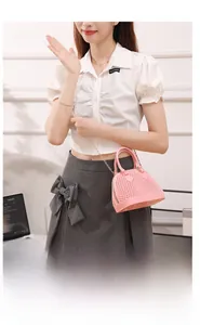 Sac à main rose texturé avec bandoulière chaîne dorée porté par un mannequin chic