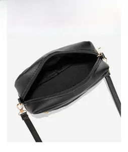 Top view of black quilted crossbody bag showing interior storage and gold zipper detail