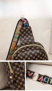 Detail of vintage clover pattern bag with colorful strap and gold metal zippers