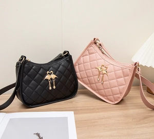 Détail de sacs bandoulière en cuir PU matelassé noir et rose avec pendentifs flamants