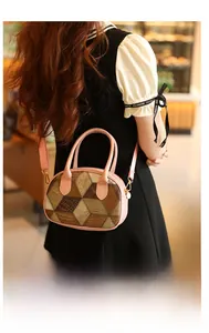 Detail of checkered crossbody bag with pink leather strap and gold hardware accents