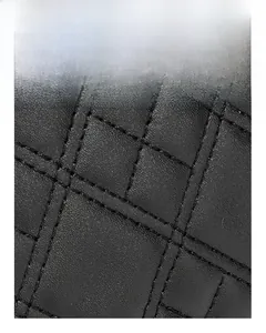 Close-up of black quilted leather handbag showing precise embroidery and grid stitching