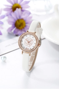Detailed close-up of rose gold watch dial with camellia pattern and sparkling crystals