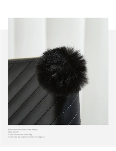 Detail of quilted black leather purse with gold zippers and a plush faux fur pompom charm