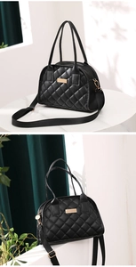 Detail view of black quilted PU leather bowling bag with gold hardware on marble table