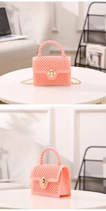 Détails du sac en gelée rose avec texture perlée et fermoir en forme de fleur dorée