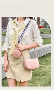 Détail du sac bandoulière matelassé rose avec sangle à motifs et petit porte-monnaie