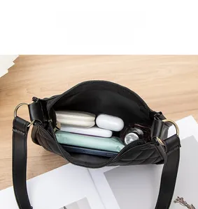 Vue intérieure montrant la grande capacité et les compartiments du sac noir matelassé