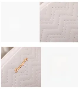 Close-up of white wave-quilted fabric texture and premium gold metal logo hardware details