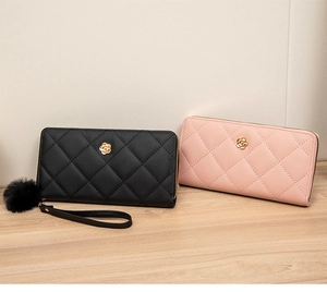 Detail of quilted faux leather long wallet with golden flower buckle and fur pompom