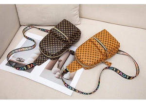 Detail of crossbody chest bags in brown and yellow with circle patterns and LOVE straps