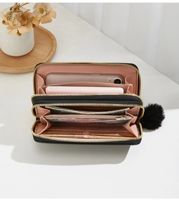 Detail view of the black multi-slot wallet interior with pink lining and dual gold zippers