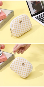 Detail of floral printed clutch with golden rose accent and chain keychain accessory