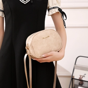 Minimalist beige wax leather crossbody bag with gold logo and adjustable shoulder strap