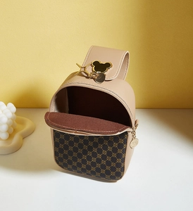 Detail of small crossbody bag with beige leather, monogram pattern and gold mouse charm