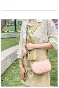 Sac à bandoulière rose matelassé avec sangle large et mini pochette porté par un modèle
