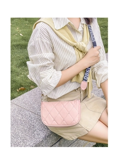 Détail du sac bandoulière rose matelassé avec motifs cœurs et large sangle tissée