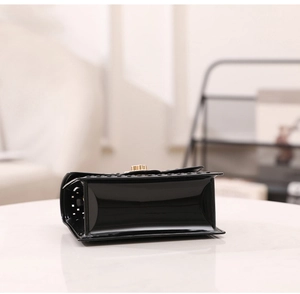 Vue latérale du sac jelly noir avec motif ajouré et bouton-pression en métal doré