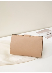 Gros plan du porte-cartes beige minimaliste avec motif floral marron sur cuir texture