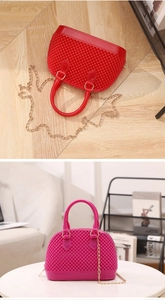 Détail de la texture sphérique et de la chaîne dorée du sac à main en PVC pour femme
