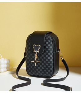 Detail of black crossbody phone bag with geometric print and gold star charm detail