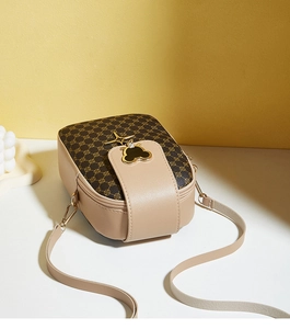 Detail of classic printed crossbody bag with golden bee charm and dual zippers