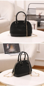 Détail du sac dôme noir en forme de coquillage avec perles brillantes et chaîne dorée